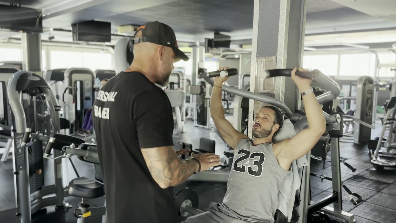 Cédric guide un client sur une machine de musculation à FreeFit Mougins